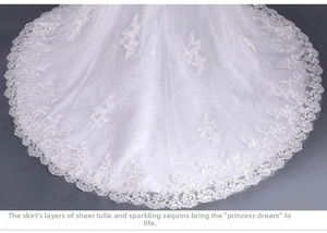 Dettaglio dell'orlo dell'abito da sposa a sirena bianco con pizzo e paillettes