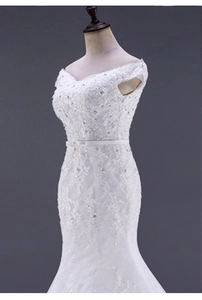 Dettaglio dell'abito da sposa a sirena in pizzo bianco con ricami floreali