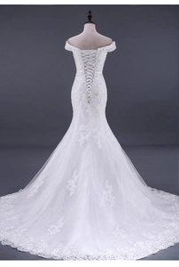 Dettaglio di applicazioni in pizzo e chiusura a stringhe sulla schiena dell'abito da sposa