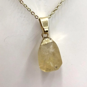 Macro detail of natural faceted yellow quartz pendant with polished golden metal clasp