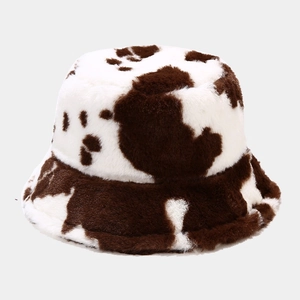 Close-up of soft faux fur bucket hat featuring a brown and white cow print pattern