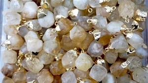 Detailed close-up of natural raw citrine stone pendants with golden metal caps