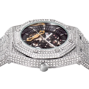 Macro view of silver diamond-encrusted skeleton watch with iced-out metal strap and screws