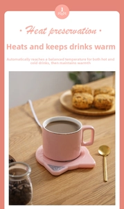 Pink ceramic cup with cat-ear electric coffee mug warmer set on a wooden table