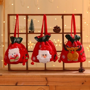 Rote Weihnachtsbeutel mit Kordelzug und Cartoon-Motiven an einem Holzregal in festlicher Kulisse