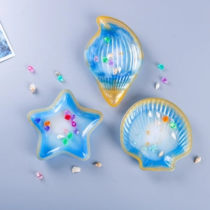 Detailed top view of resin ocean trays in starfish, conch, and shell shapes with gold trim