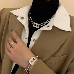 Primer plano del collar con colgante de letra B plateada y pulsera a juego en modelo