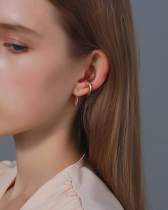 Close-up of a polished gold snake-style ear cuff worn on the earlobe for a punk look