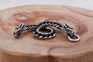 Macro shot of double dragon head clasps on a black braided leather bracelet for men
