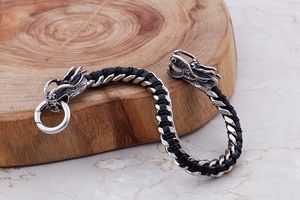 Detail of vintage silver dragon head clasp on black braided leather bracelet for men
