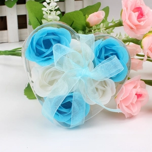 Detail of heart-shaped gift box with six blue and white scented soap roses and blue ribbon