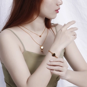 Parure de bijoux pour femme avec collier et bracelet double cœur en acier plaqué or 18K