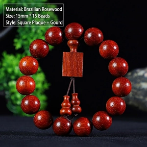 Macro detail of Brazilian Rosewood beads with a square plaque and gourd charm pendants