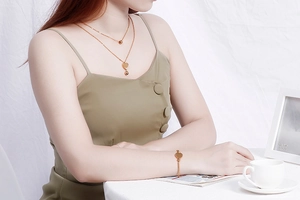 Détail d'un ensemble collier et bracelet coeur double couche plaqué or 18K sur un mannequin