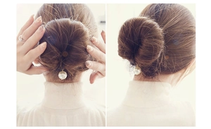 Detail of elegant white pearl hair tool for bun styling on golden metal connector