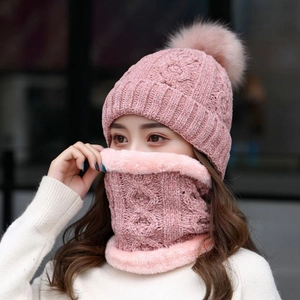 Dettaglio del set berretto e sciarpa in maglia di ciniglia rosa con pompon soffici