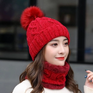 Dettaglio del set cappello e sciarpa in maglia di ciniglia rossa con pompon e pile