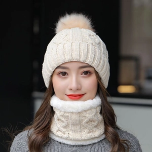 Dettaglio cappello in maglia bianco avorio con pompon e scaldacollo foderato in pile