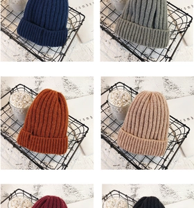 Detailed grid view of chunky knit beanies in navy, grey, and burgundy colors