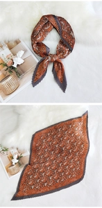Macro detail of burnt orange paisley accordion pleated scarf on white plush carpet