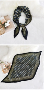 Detail of pleated silk scarf with vintage geometric patterns and deep green floral prints