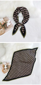 Detail of green and pink geometric plaid pleated silk scarf on a white plush rug
