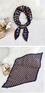 Close-up of pleated silk scarf with blue and brown checkered pattern and wavy edges