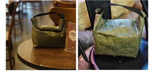 Detail of forest green Tyvek lunch bag showing unique wrinkled texture and roll-top closure