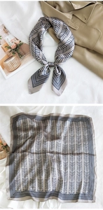 Detailed pattern of taupe and navy silk scarf paired with a stylish khaki trench coat
