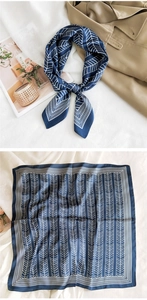 Close-up of a navy blue square silk scarf with white wheat patterns on satin fabric