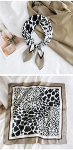Detail of black and white leopard print square scarf showing styling on a trench coat