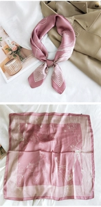 Flat lay of dusty pink silk scarf with abstract patterns on khaki trench coat