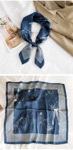 Navy and white patterned silk scarf flat lay with trench coat and lifestyle items