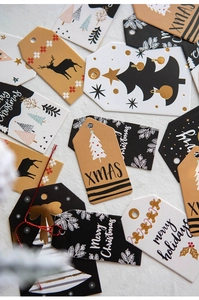Close-up of assorted Christmas gift tags with gold foil patterns and twine details