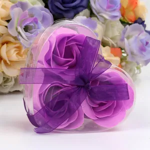 Three purple soap flower roses in heart-shaped gift box with violet ribbon bow
