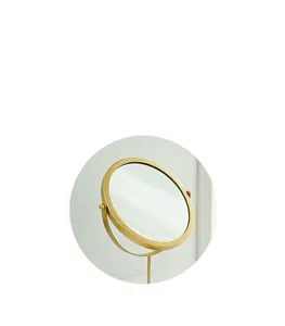 Dettaglio di uno specchio da trucco rotondo moderno con cornice in metallo dorato