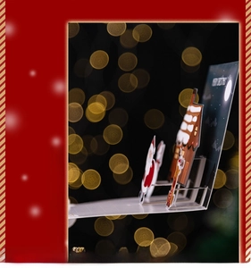 Macro detail of 3D pop-up Christmas card featuring Santa and cottage with golden bokeh
