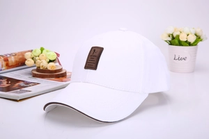 Close-up of a white baseball cap featuring a brown leather patch and stylish brim details