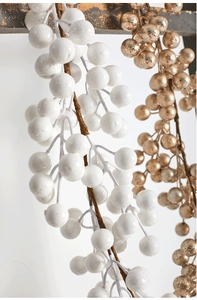 Détail de tiges de baies artificielles blanches et dorées pour décoration de Noël