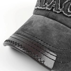 Detail der grauen Vintage-Baseballkappe mit BLACK-Stickerei und Lederkantennaht