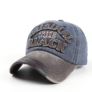 Detail einer Vintage-Baseballkappe aus gewaschenem Denim mit BLACK-Stickerei und Used-Look