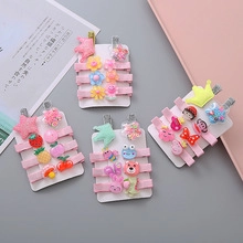 Gros plan d'un lot de barrettes pour enfants avec motifs fruits, animaux et étoiles