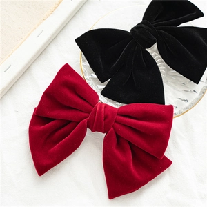 Elegant pair of large velvet bow hair clips in classic black and red for women