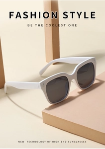 Close-up of stylish white sunglasses with grey lenses on geometric display props