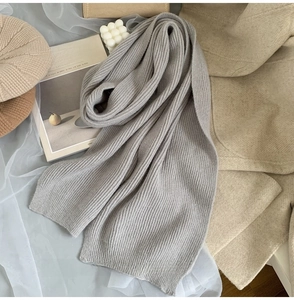 Close-up of soft gray ribbed knit winter scarf with stylish fashion accessories