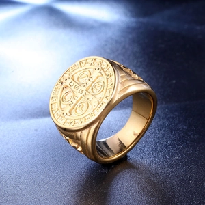 Macro view of gold Saint Benedict Medal ring showing cross detail and embossed Latin letters