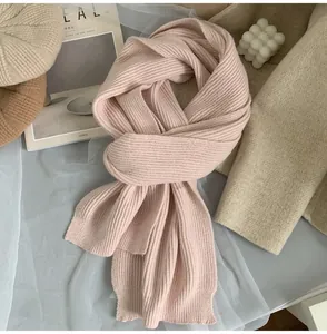 Close-up of soft pink knitted scarf with vertical rib texture in a cozy scene