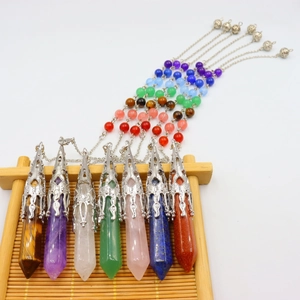 Set of seven hexagonal crystal pendants on a bamboo rack for yoga and meditation jewelry