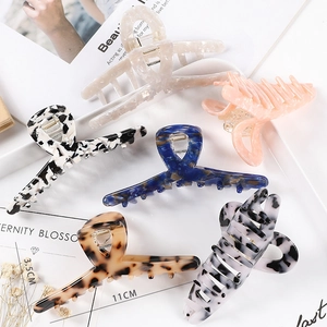 Detail view of 11cm large acetate hair claw clips in six vintage marbled color patterns