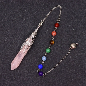 Macro detail of rose quartz hexagonal pendant with silver flower filigree and seven chakra beads